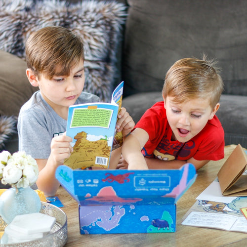 Two brothers opening up WompleBox: Argentina as older boy reads The Book of Mystery