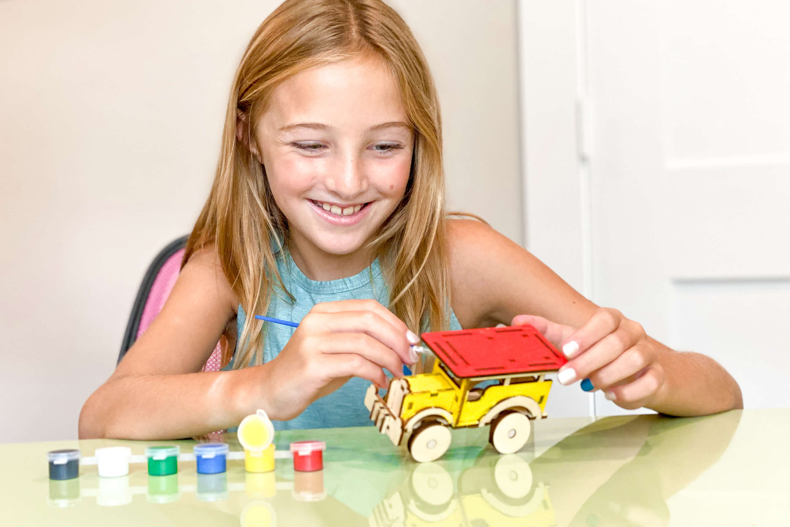 Womple Studios girl playing with jeepney craft from the Philippines WompleBox kit