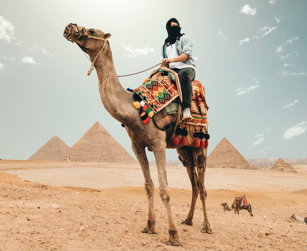 Women riding on the back of a camel in the desert