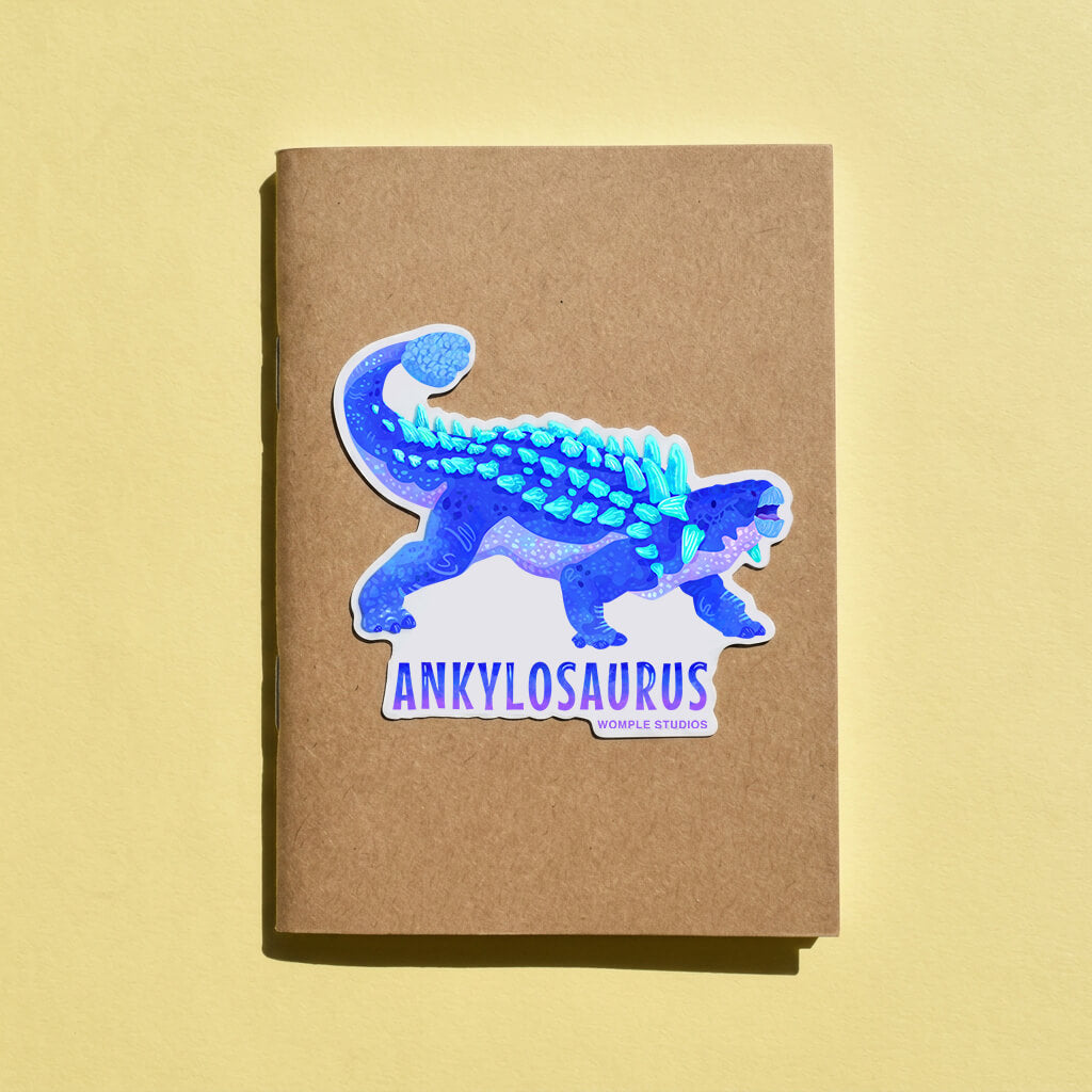 Sticker of an ankylosaurus on a brown notebook with a yellow background