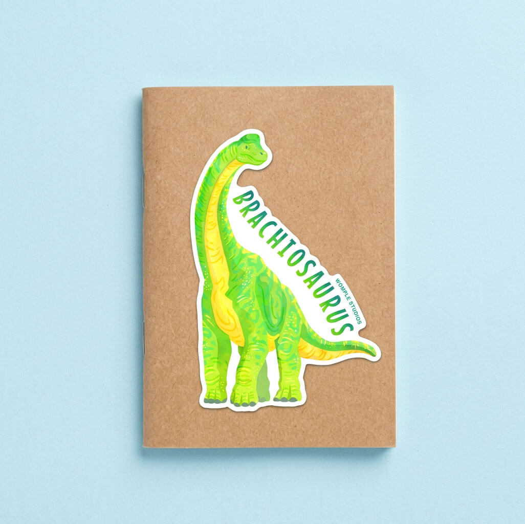 Notebook with a Brachiosaurus sticker on a light blue background