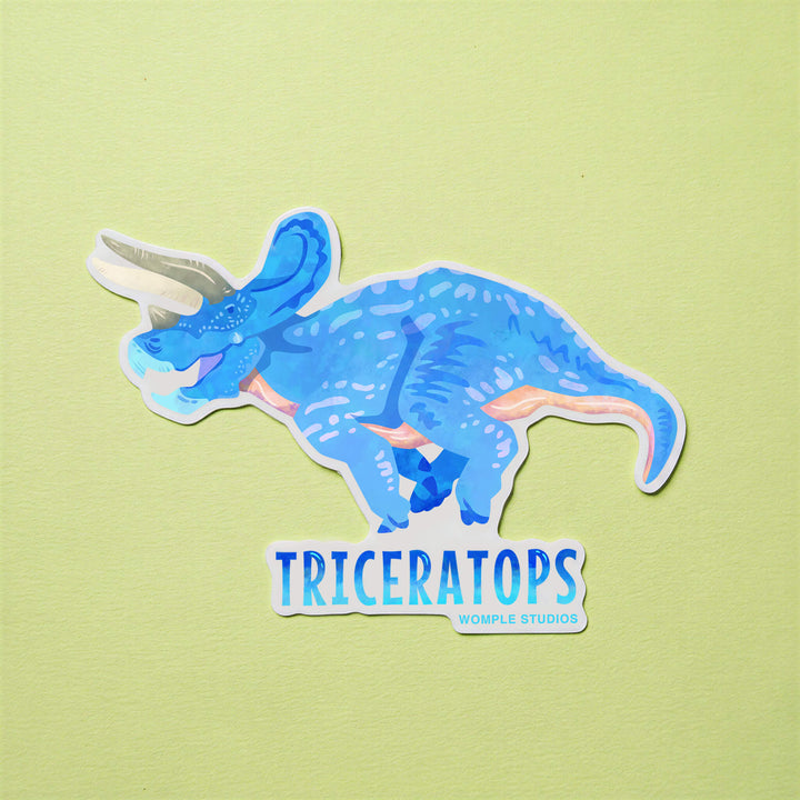 Sticker of a blue triceratops on a green background