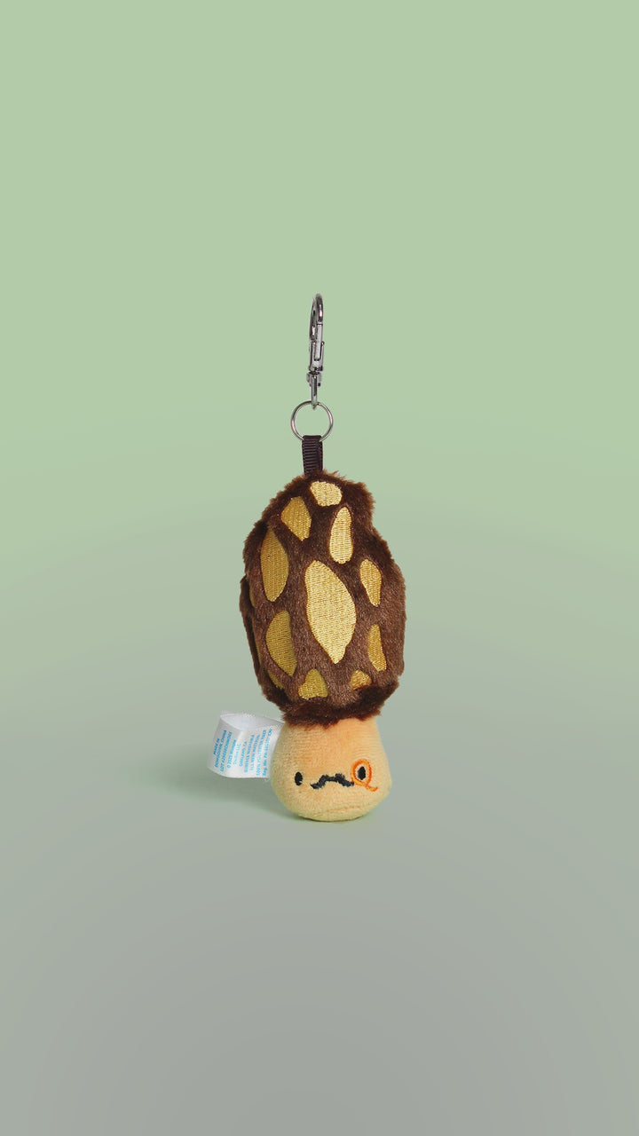 Rotation video of a plush toy true morel mushroom keychain with a face on a white background