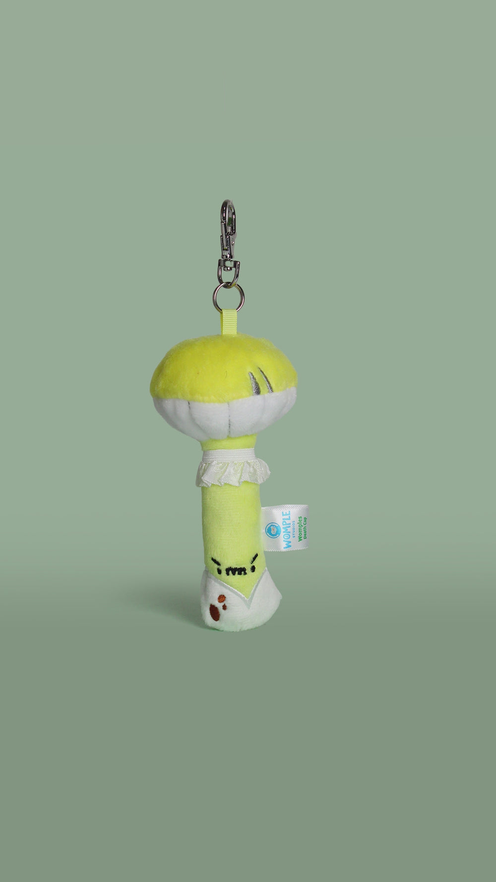 Rotating video of a plush toy death cap mushroom keychain with a face on a green background