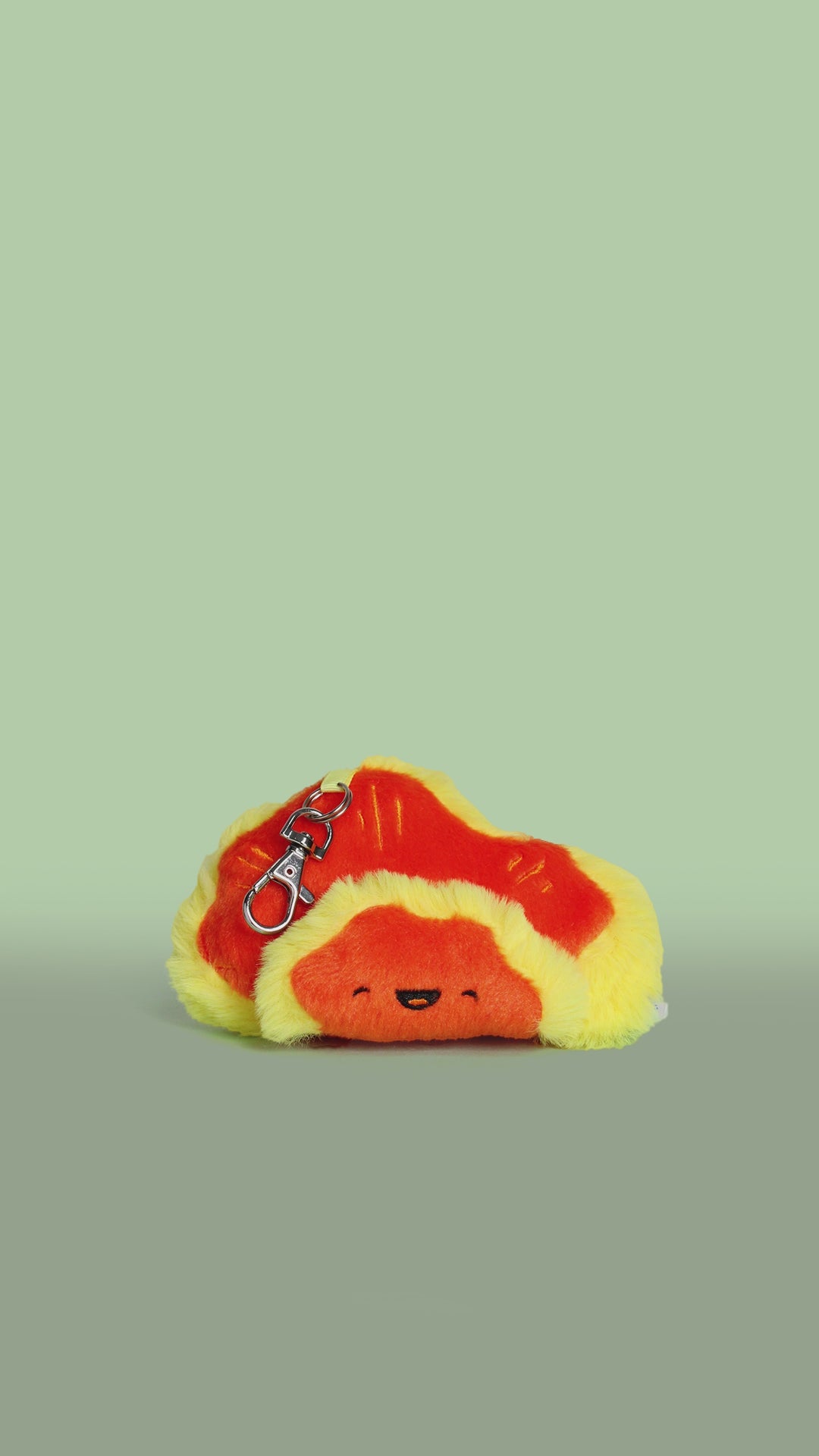 Rotating video of a plush toy chicken of the woods mushroom with a face on a green background