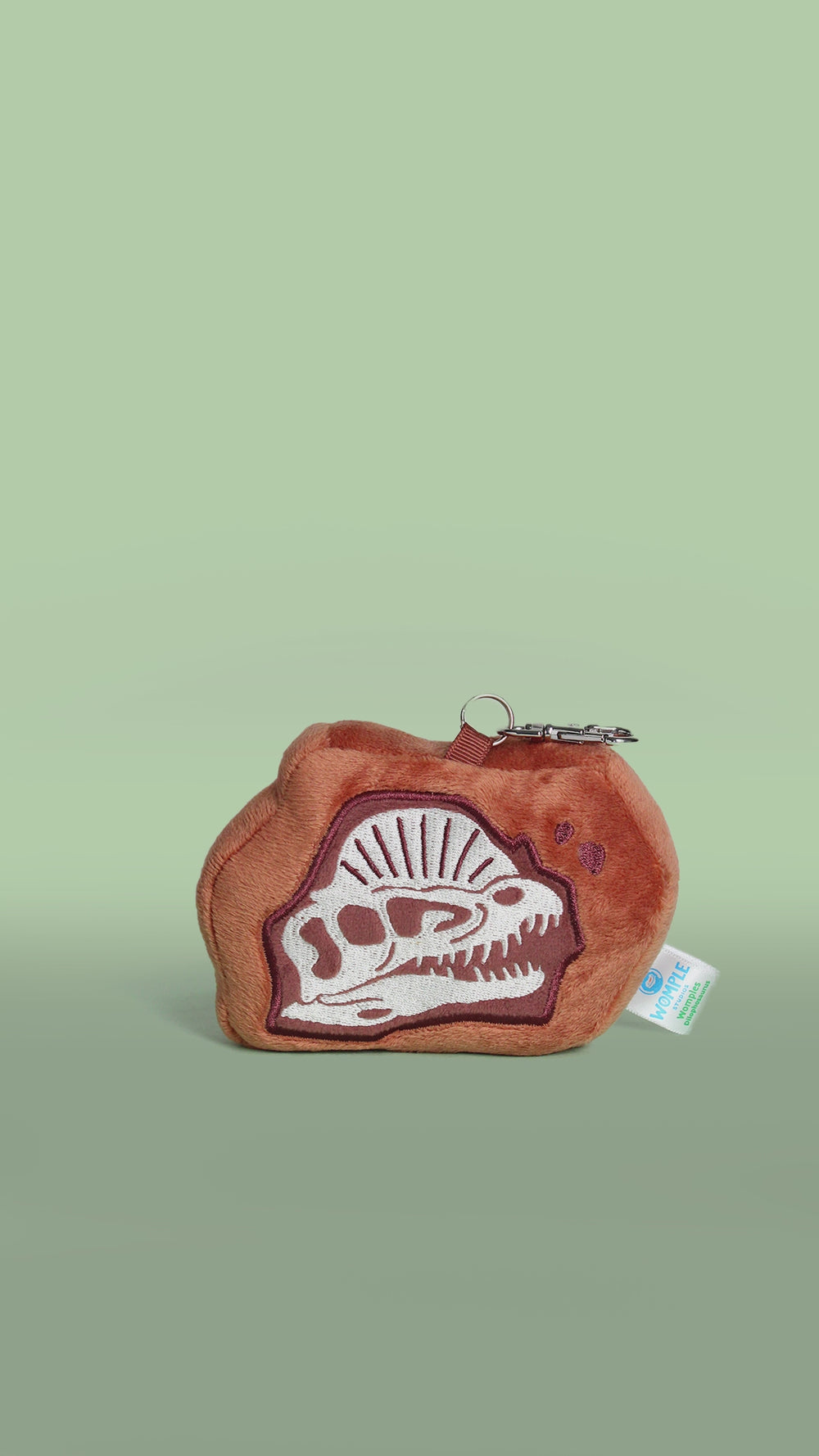 Brown plush bag charm with dinosaur fossil dilophosaurus design on a white background rotating