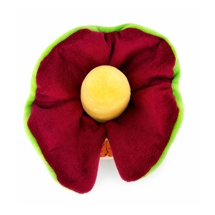 A top-down view of a plush toy with deep burgundy interior, a bright green outer edge, and a round cone yellow center, photographed on a plain white background.
