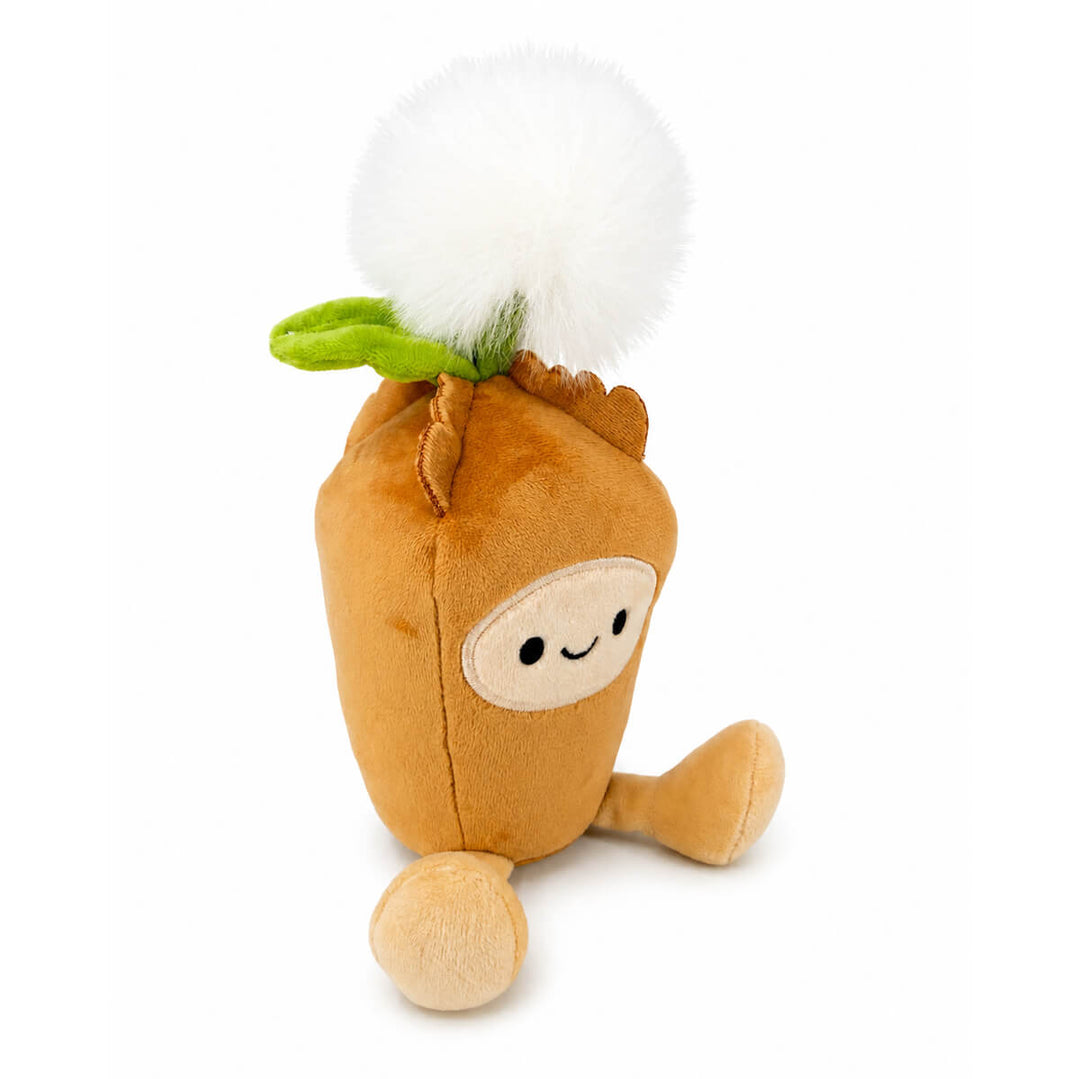 A plush dandelion toy in warm tan-brown with a white fluffy pom-pom seed head on top, green leaf accents, and a small embroidered face, photographed on a clean white background.