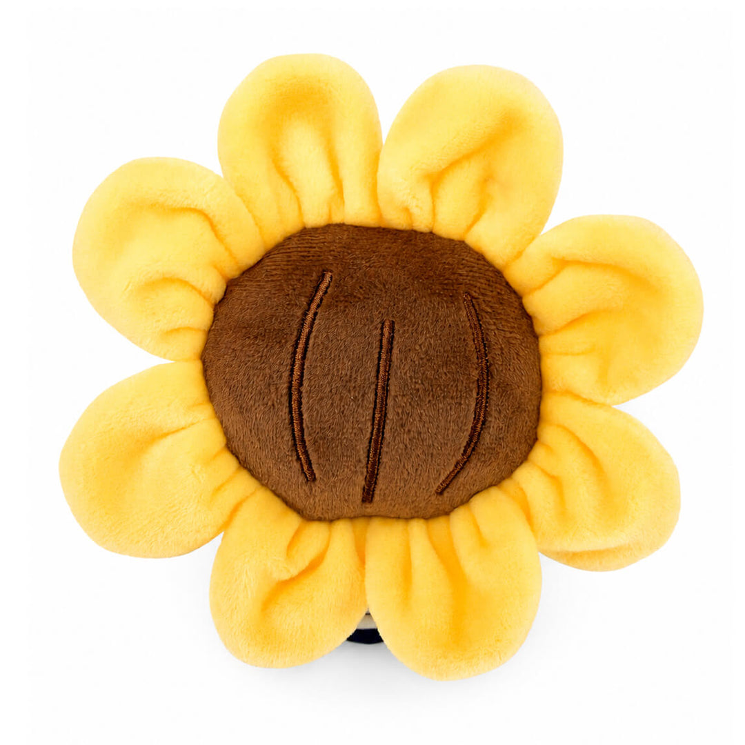 A top-down view of a plush toy sunflower with soft yellow petals and a brown center, photographed on a plain white background.